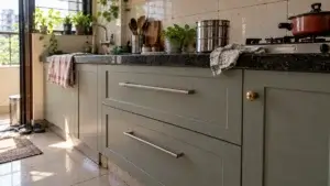 Kitchen shutters with a steel bar pull on a drawer and a brass knob on a small door